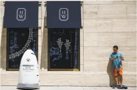  ?? Michael Ciaglo / Houston Chronicle ?? A security robot nicknamed ROD2 drives toward Daniel Webb as it patrols the sidewalks and parking garage at River Oaks District in Houston.