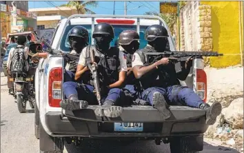  ?? Guerinault Louis Anadolu Agency ?? POLICE take security measures at the funeral Tuesday of three officers killed by gangs in Haiti. Armed groups have taken advantage of the political crisis precipitat­ed by the 2021 slaying of President Jovenel Moise.