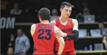  ?? DAVID JABLONSKI / STAFF ?? Ryan Mikesell (right) hugs Jack Westerfiel­d in the final seconds of Dayton’s NIT loss at Colorado on Tuesday.