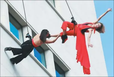  ?? GONG BING / XINHUA ?? Actors perform an “air tango” on the wall of a building in Brussels, Belgium, as part of the ongoing Brussels Tango Festival.