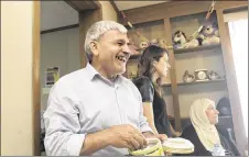  ??  ?? Taha Youssef laughs at a story during dinner. He was a farmer in Syria before the war. In the U.S., he says, “I feel welcome all the time.”