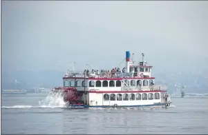  ?? CP PHOTO ?? Smoke from wildfires burning in central British Columbia hangs in the air as tourists tour the harbour on the Constituti­on paddlewhee­l boat, in Vancouver, B.C., on Thursday.