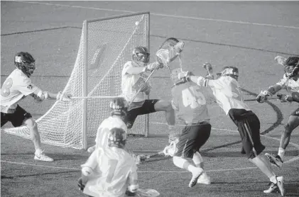  ?? KARL MERTON FERRON/BALTIMORE SUN ?? Midfielder Brendan Bomberry (45) is hit from behind by midfielder Tal Bruno while scoring the game-winner on goalie Gerald Logan.