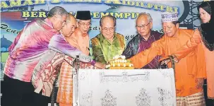  ??  ?? SIMBOLIK: Uggah (empat kiri) memotong pulut kuning sebagai simbolik perasmian Majlis RamahTamah Aidilfitri Kampung Melayu Betong. Turut kelihatan Rentap (tiga kiri) dan Jabu (lima kiri).