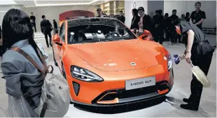  ?? REUTERS ?? A worker cleans a Xiaomi SU7 electric vehicle displayed at Auto China in Beijing yesterday.