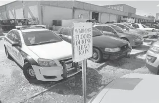  ?? CARLINE JEAN/SUN SENTINEL PHOTOS ?? Behind the police station, a parking lot floods badly.