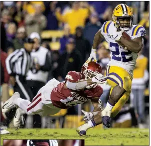  ?? NWA Democrat-Gazette/BEN GOFF ?? ABOVE LSU running back Clyde Edwards-Helaire breaks the tackle of Arkansas strong safety Myles Mason on his way to a third-quarter touchdown Saturday at Tiger Stadium in Baton Rouge. Edwards-Helaire finished with 188 yards on 6 carries and scored 3 times in LSU’s 56-20 victory.