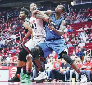  ?? USA TODAY SPORTS ?? Houston Rockets center Nene is sandwiched by Minnesota Timberwolv­es players during their NBA game at Toyota Center, Houston on Saturday. The Rockets won 142-130.