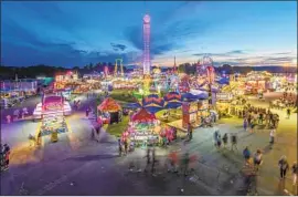  ?? Craig Hudson Charleston Gazette-Mail ?? THE STATE FAIR glows in 2018 in Fairlea, W.Va. Census data show West Virginia lost a higher percentage of its residents over a decade than any other state.