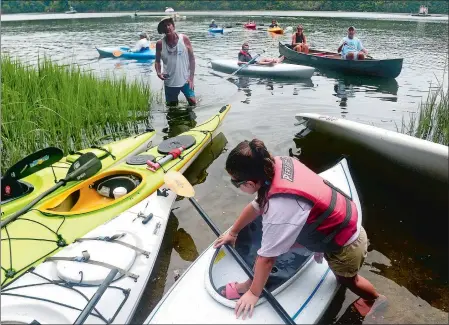  ?? PHOTOS BY SARAH GORDON/THE DAY ?? Taylor O’Pasek, 8, visiting from Long Island, climbs into her boat during the Save the River-Save the Hills Kayak Regatta on Sunday on the Niantic River in Waterford. The 15th annual event featured a paddle along the river and the dedication of the new Grimsey Beach on Oswegatchi­e Road.