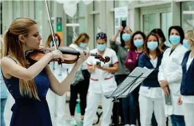  ??  ?? La violinista Flavia Fiamma Paolucci suona per i sanitari all’ospedale di Tor Vergata