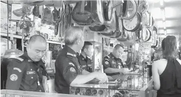  ??  ?? Enforcemen­t officers during their round at one of the premises in Miri.