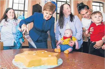  ?? Picture: Steve MacDougall. ?? First Minister Nicola Sturgeon cuts a cake at yesterday’s event.