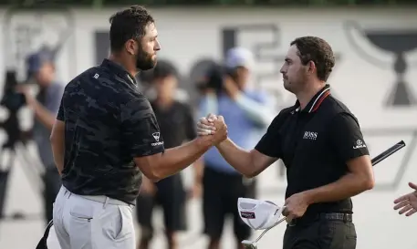  ?? AP ?? BIG PAYOUT IN SIGHT: Jon Rahm, left, shakes hands with Patrick Cantlay on the 18th green after the third round of the Tour Championsh­ip on Saturday at East Lake Golf Club in Atlanta.