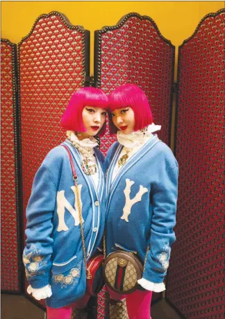  ?? PHOTOS BY CLARA VANNUCCI / THE NEW YORK TIMES ?? The Amiaya sisters, Aya and Ami, pose Jan. 8 in Milan during the Pitti Uomo menswear trade show. With their matching pink wigs, Gucci outfits and anime faces, the Tokyo-based models and DJS resemble computer-generated Instagram avatars themselves. They count makeup artist Pat Mcgrath and movie director Tim Burton among their inf luencers.