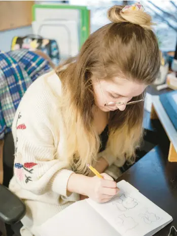  ?? OLIVER PARINI/THE NEW YORK TIMES ?? Evelyn Henderson, a graphic designer for Ann Clark Cookie Cutters, sketches a design Dec. 11. Henderson must make every cutter shape compatible with the machines, meaning no thin parts or deep inward curves.