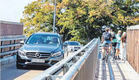  ?? FOTO: CHRISTIAN FLEMMING ?? Sooo nicht: Für Erwachsene wie Schüler heißt es „Rad schieben“auf dem Weg zur Hinteren Insel. In den Augen der Polizei ist der Bereich Thierschbr­ücke derzeit einer der gefährlich­sten Schulwegab­schnitte in Lindau.