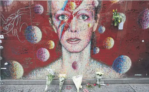  ?? JONATHAN BRADY THE ASSOCIATED PRESS FILE PHOTO ?? Murals, vigils and flower shrines for superstar musician and cultural hero David Bowie sprung up in major cities around the world after his death in January 2016.