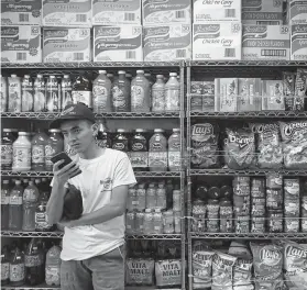  ?? Photos by Kelsey Walling / Associated Press ?? Deno Eranba stands by food in a store at the Galveston port. Cruise line employees have limited time to shop for supplies before they have to return to the ship.