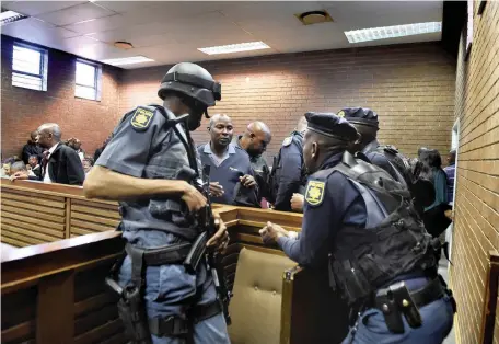  ?? Picture: Itumeleng English/African News Agency (ANA) ?? BIG GUNS: Heavy police presence at the Roodepoort Magistrate’s Court where four suspects appeared for alleged involvemen­t in three cash-in-transit heists.