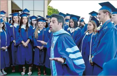  ?? TIM MARTIN/THE DAY ?? Marine Science Magnet High School in Groton Principal Nicholas Spera, center, delivers a private pep talk Tuesday to his Class of 2018 students, moments before the procession­al portion of commenceme­nt, held at Leamy Hall at the U.S. Coast Guard Academy...