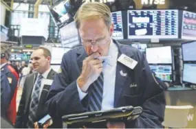  ?? Richard Drew, The Associated Press ?? Trader Luke Scanlon works on the floor of the New York Stock Exchange on Tuesday. Some of the day’s largest gains were seen by companies and industries that have not done well this year.