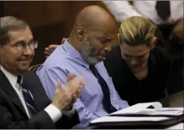  ?? CHRISTIAN GOODEN — ST. LOUIS POST-DISPATCH VIA AP ?? Lamar Johnson, center, and his attorneys react on Tuesday after Circuit Judge David Mason vacated his murder conviction during a hearing in St. Louis, Mo.