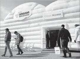  ?? Sean Gallup Getty Images ?? AMAZON WEB SERVICES hosts a cloud pavilion at the 2016 CeBIT digital technology trade fair in Germany. The Web services business is growing rapidly.