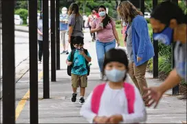  ?? HYOSUB SHIN / HYOSUB.SHIN@AJC.COM ?? Students wearing masks arrive for the first day of school amid the coronaviru­s pandemic Aug. 26. Gov. Brian Kemp didn’t reclassify teachers as “critical” workers Monday, but he said Tuesday he still might.