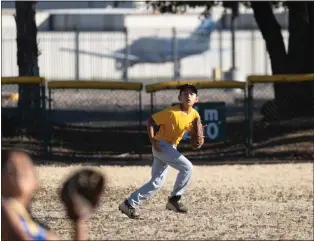  ?? PHOTO BY JIM GENSHEIMER ?? With a parked plane in the background, Aiden Barragan, 9, positions himself in center field to make a catch during practice at Eastridge Little League diamond recently in San Jose. Santa Clara County officials have set a Tuesday deadline for closing the fields.