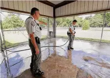  ?? Karen Warren/Staff file photo ?? Katy Animal Control director David Brown, left, watches animal control officer Spencer Antinoro wash down a back patio last year. Gerber accused both Brown and Antinoro of misconduct.