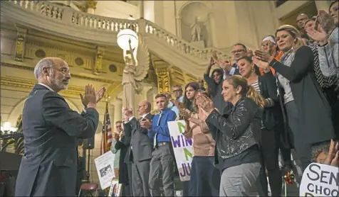  ?? Steve Mellon/Post-Gazette ?? Gov. Tom Wolf stands with victims of sexual abuse and their families and supporters during a rally in the Capitol on Monday.
