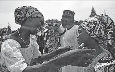 ?? [OLAMIKAN GBEMIGA/THE ASSOCIATED PRESS] ?? Family members celebrate in Abuja, Nigeria, on Saturday as one embraces a relative who was among the 82 schoolgirl­s recently released after more than three years in Boko Haram captivity. Five commanders from the extremist group were exchanged for the...