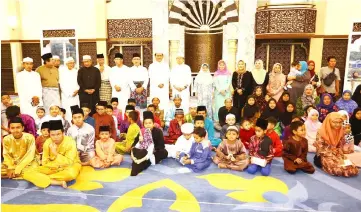  ??  ?? Abang Johari (standing, 10th left), flanked by Juma’ani on his left and Dr Abdul Rahman, joins the aid recipients and members of the mosque committee in a group photo. — Photo by Muhammad Rais Sanusi