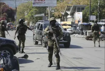  ?? Odelyn Joseph/Associated Press ?? Members of the General Security Unit of the National Palace set up a security perimeter Saturday around one of the three downtown stations after police fought off an attack by gangs on Friday, in Port-au-Prince, Haiti.