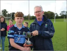  ??  ?? An Tochar’s Éanna Nolan is presented with the ‘A’ cup by Owen Doyle. The midfielder also picked up the Man of the Match award.