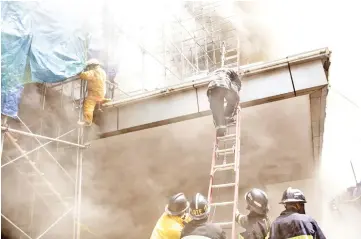  ?? — AFP photo ?? Firemen try to escape from heavy smoke at the Waterfront Manila Pavilion building.