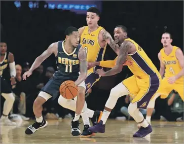  ?? Photograph­s by Sean M. Haffey Getty Images ?? KYLE KUZMA of the Lakers, middle, and Kentavious Caldwell-Pope, a defensive specialist who is trying to help his new teammates become more proficient in that area, try to stop Monte Morris of Denver.