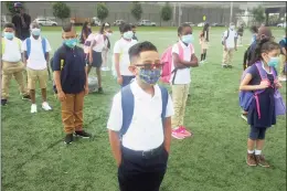  ?? Ned Gerard / Hearst Connecticu­t Media ?? Third-grader Angelo Barrera and his classmates line up a safe social distance before entering Roosevelt School for the first days of class in Bridgeport in September.