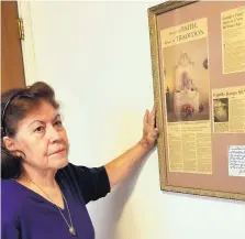  ?? JOLINE GUTIERREZ KRUEGER/JOURNAL ?? Rachel Martinez reads from a pair of 1998 newspaper clippings about the velorio hosted by her mother. That year marked the 80th velorio, a gathering involving prayer and thanks and family, held after her grandfathe­r made a vow in 1918 to honor Our Lady...