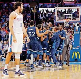  ?? [PHOTO BY NATE BILLINGS, THE OKLAHOMAN] ?? The Minnesota Timberwolv­es celebrate Andrew Wiggins’ game-winning shot while Oklahoma City’s Alex Abrines walks toward the bench after Sunday night’s game at Chesapeake Energy Arena.