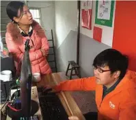  ??  ?? Luo Rong helps a neighbor search online for a television to buy at Rural Taobao service center.