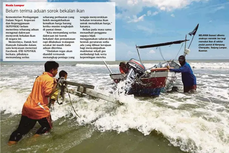  ?? FOTO: MUHAMMAD ASYRAF SAWAL ?? NELAYAN (kanan) dibantu anaknya menolak bot bagi memukat ikan di sekitar pesisir pantai di Kampung Chempaka, Tanjung Lumpur, Kuantan.