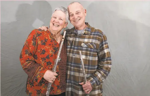  ?? Liz Hafalia / The Chronicle ?? Above: Associate principal flute Robin McKee (left) met her husband, principal flute Tim Day, when they were teenagers in Pennsylvan­ia. At left: McKee in performanc­e at Davies Symphony Hall.