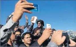  ??  ?? Joy before bloodshed: Afghan civilians take pictures with a Taliban in Kabul.