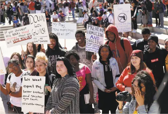 ?? Photos by Michael Macor / The Chronicle ?? Pittsburgh High students carry signs and listen to speeches during Friday’s Day of Action event against gun violence. Some 3,000 students attended the event.
