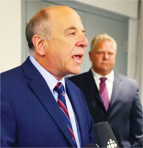  ?? DAVE ABEL/POSTMEDIA FILES ?? Dr. Rueben Devlin was at Doug Ford’s side when he gave an update on the condition of Ford’s brother Rob in 2014. Now, the former hospital CEO is heading a premier’s council aimed at reducing overcrowdi­ng in the Ontario health care sector.