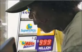  ?? Mel Melcon Los Angeles Times ?? GREGORY PURVIS of L.A. buys a Mega Millions ticket at Bluebird Liquor in Hawthorne, where the line of customers wound around the parking lot on Friday.