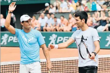  ?? CHRISTOPHE SIMON / AFP ?? Rafael Nadal y Novak Djokovic, ayer en Roland Garros durante una exhibición para los niños