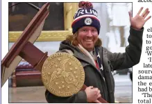  ??  ?? ANARCHY IN THE US: A triumphant rioter hauls Speaker Nancy Pelosi’s lectern off over his shoulder